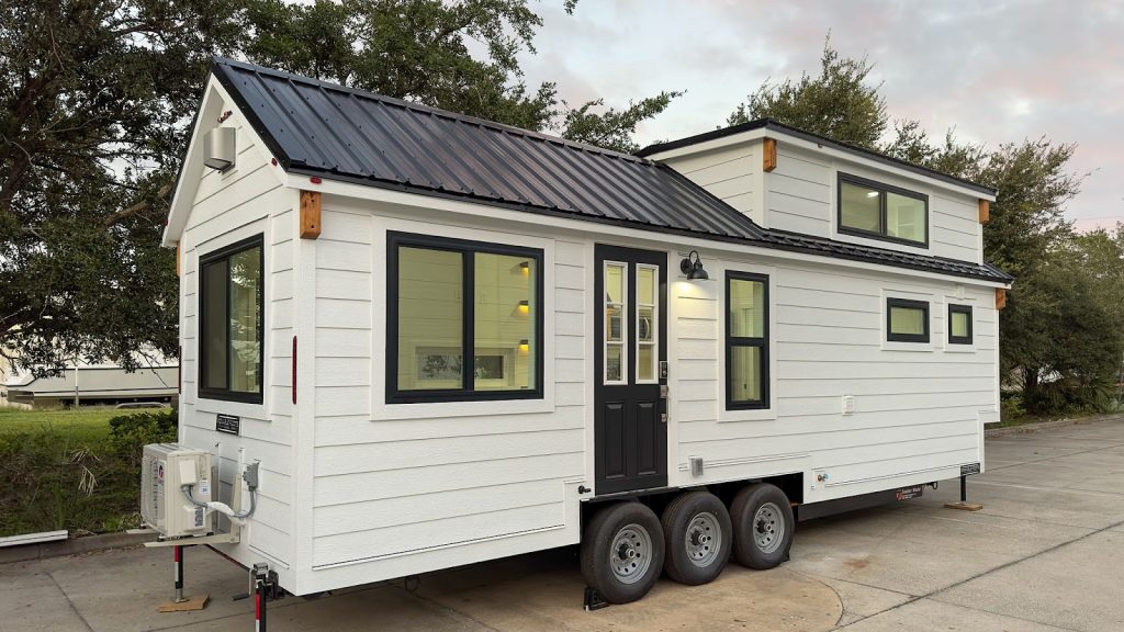 Modern tiny home with compact design, loft bed, and smart storage solutions.
